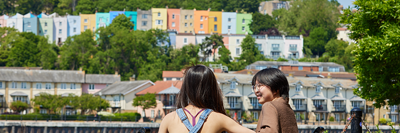 Students in front of colourful houses in the harbourside